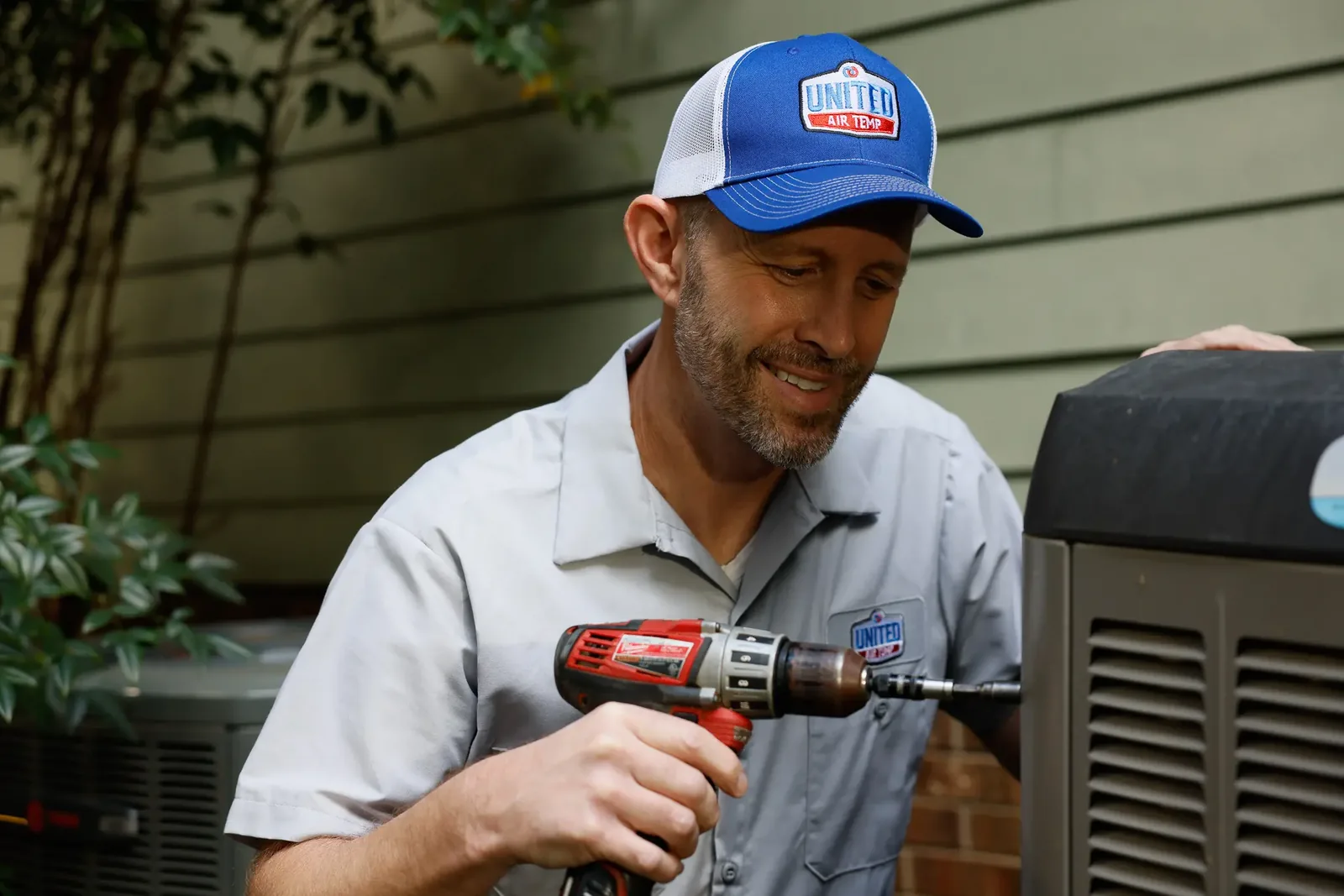 HVAC technician servicing an outdoor residential cooling unit