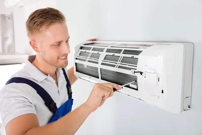 Technician checking a wall-mounted home comfort system