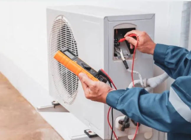 Technician using an electrical meter to test HVAC controls